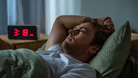 Мужчина лежит в кровати и не может уснуть